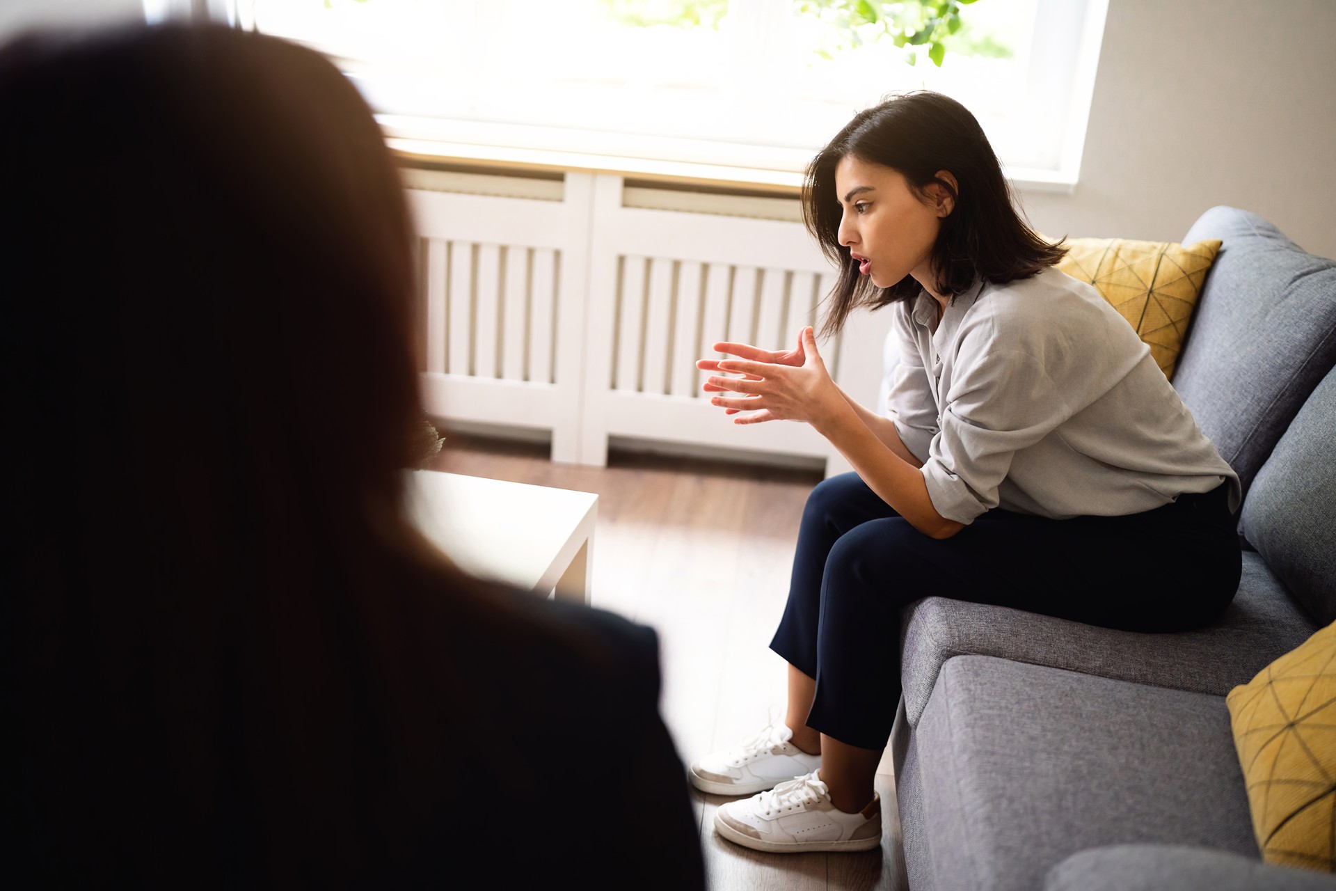 Mujer joven compartiendo sus pensamientos y emociones en la terapia